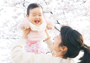 桜の木の下で笑う赤ちゃん