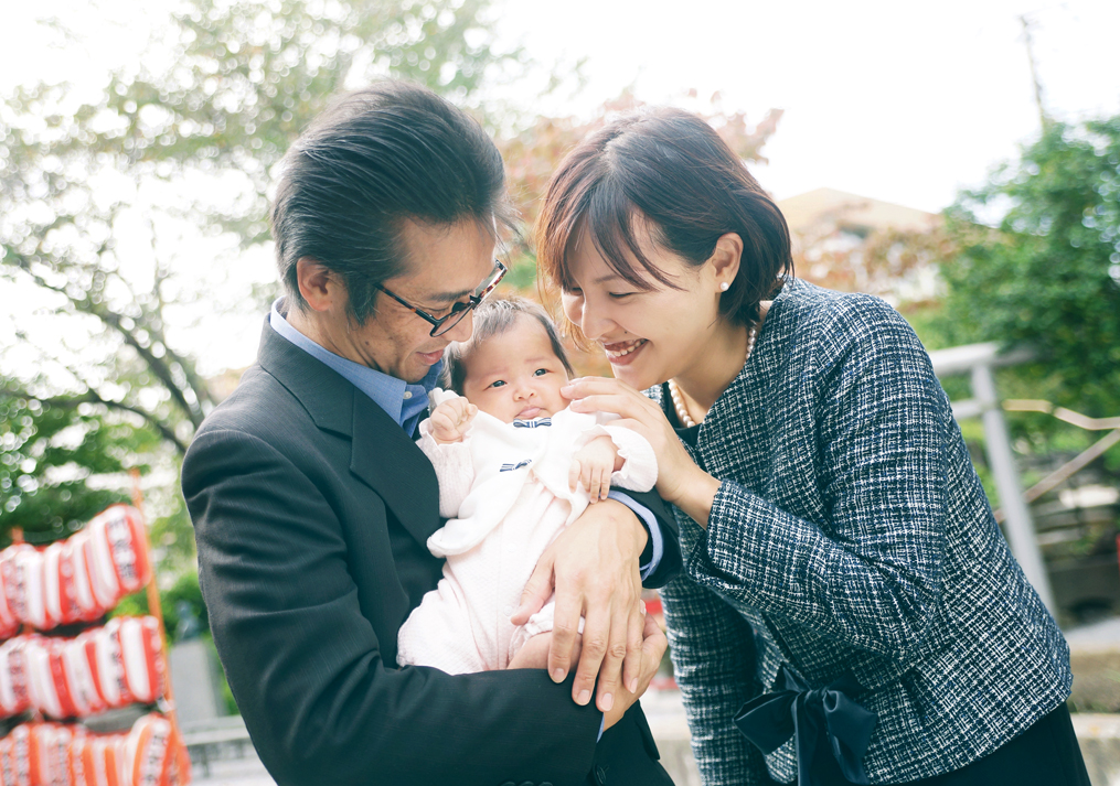 お宮参りでの赤ちゃんを抱っこするパパとママ