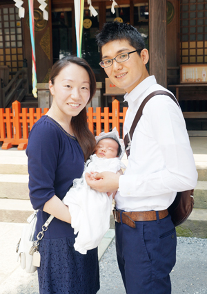 本殿の前で赤ちゃんを抱っこするパパとママ
