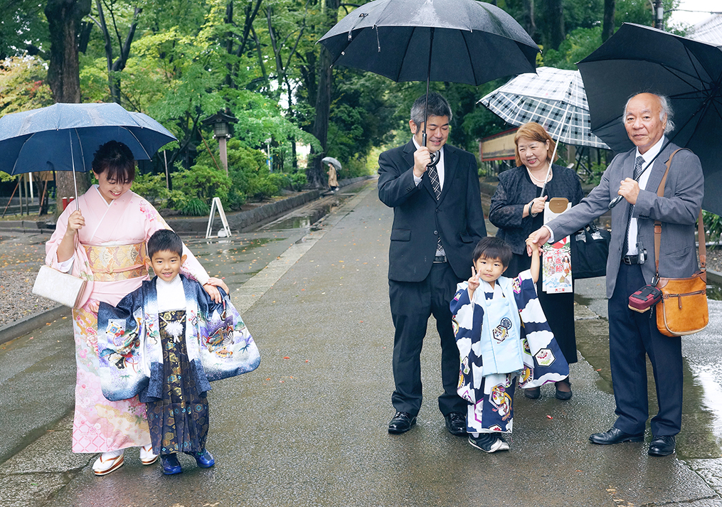 傘をさして参道を歩く家族