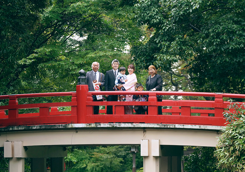 赤い橋の上で手を振る家族