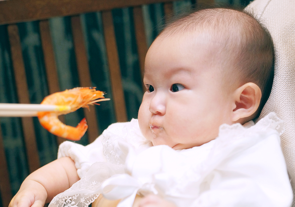 お食い初めの赤海老を見てびっくりする赤ちゃん