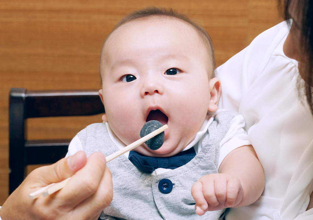 歯固めの石を食べようとする赤ちゃん