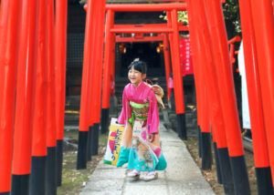 七五三出張撮影で千本鳥居の中でピンク色の着物をきた7歳女の子