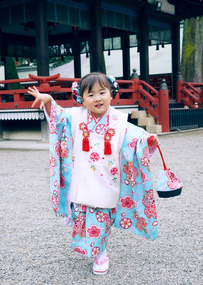 大宮氷川神社の神楽殿の前でポーズをとる七五三の女の子