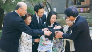 葛飾八幡宮の境内でお宮参りの赤ちゃんを囲む祖父母