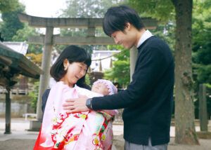 意富比神社（船橋大神宮）の鳥居前でお宮参りの赤ちゃんを抱っこするママ
