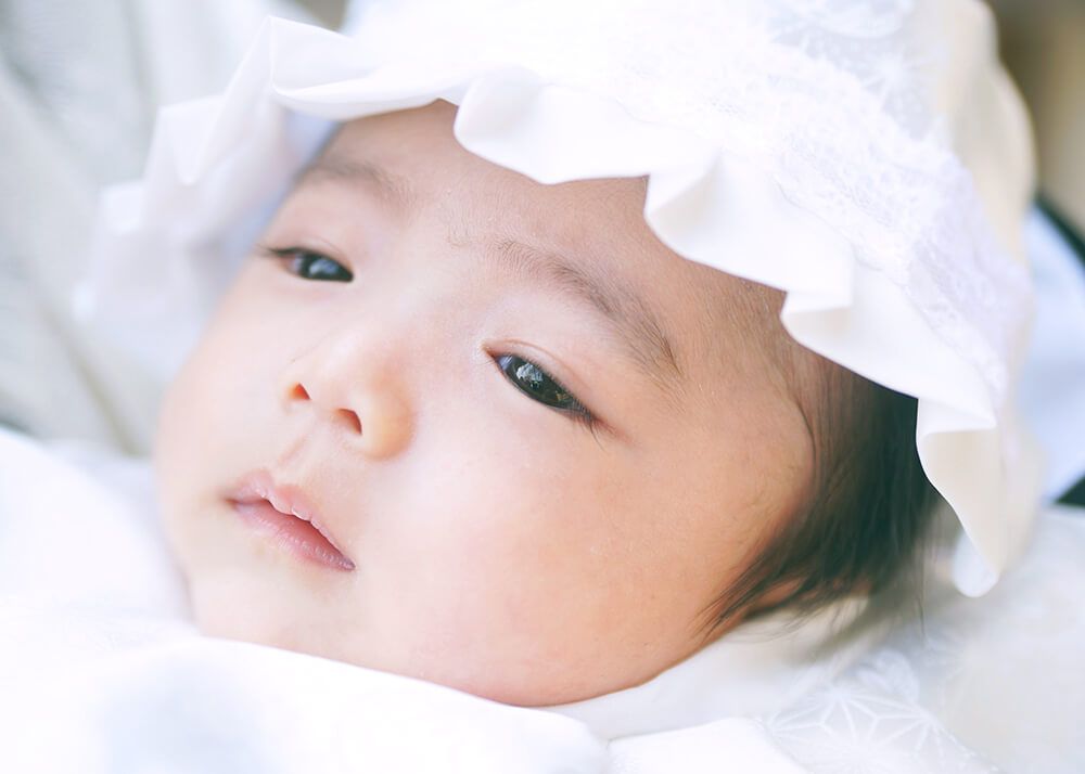 お宮参りで眠そうな赤ちゃん