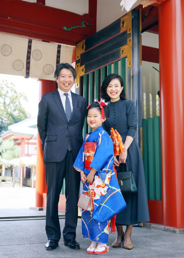 赤坂日枝神社の神門前で青色の着物を着た七五三女の子と家族