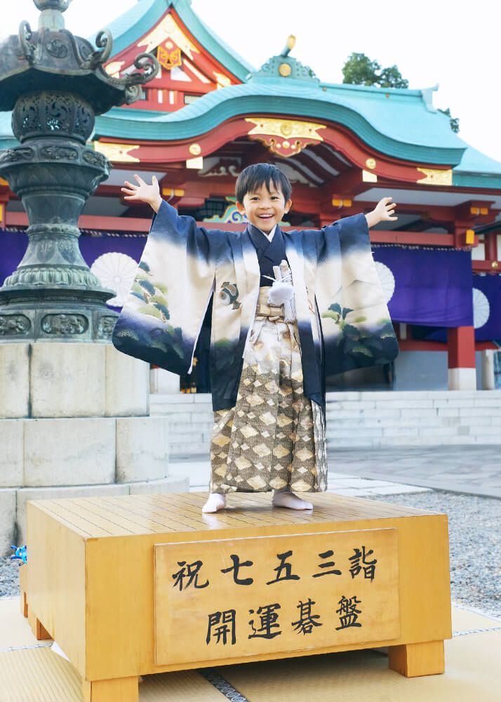 赤坂日枝神社の本殿前で七五三の碁盤の上でポーズをとる男の子