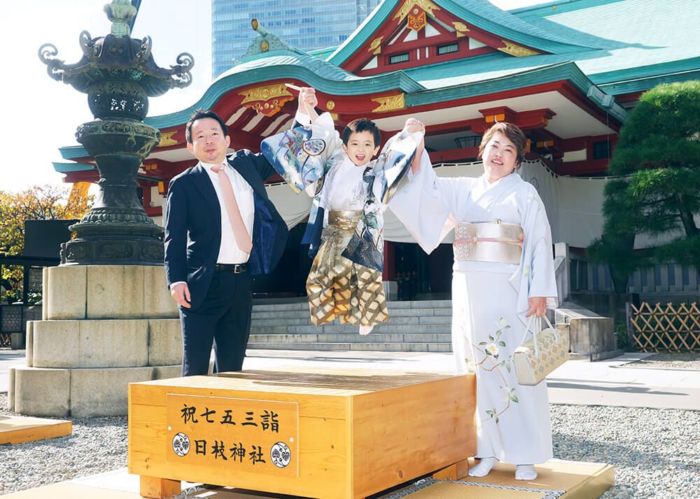 赤坂日枝神社の本殿前で七五三の碁盤の上でジャンプする男の子