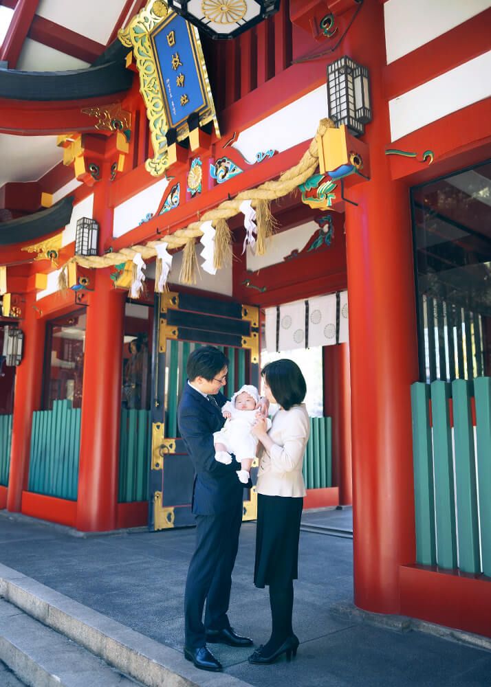 赤坂日枝神社でのお宮参りで神門の前で赤ちゃんを抱っこするパパ