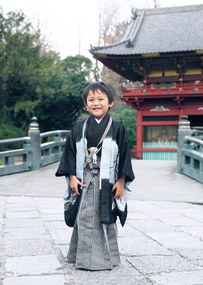 根津神社の楼門の前でポーズをとる七五三の5歳男の子