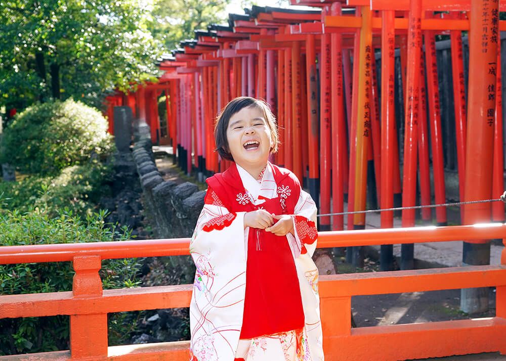 根津神社の千本鳥居の前でポーズをとる七五三の3歳女の子