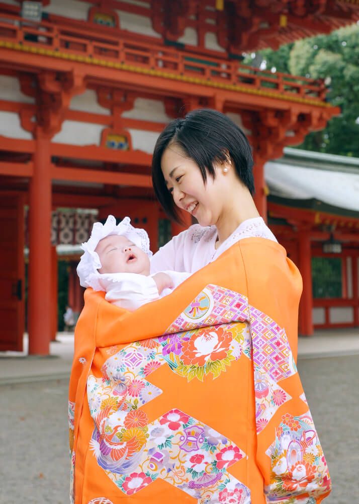 お宮参りの出張撮影で大宮氷川神社の楼門の前で赤ちゃんを抱っこするママ