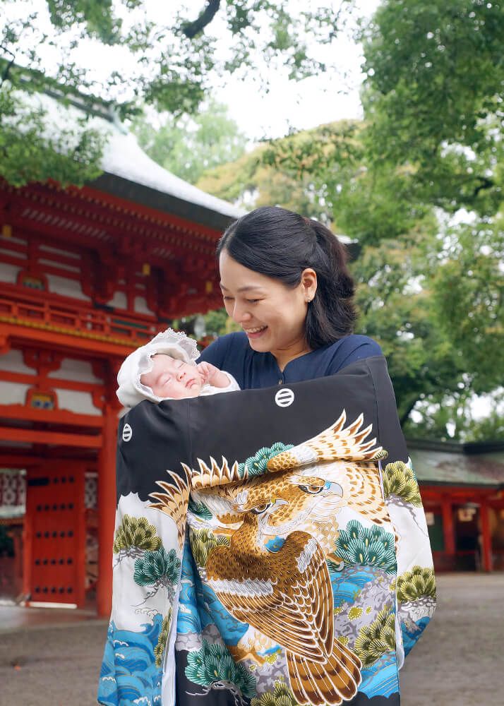 お宮参りの出張撮影で大宮氷川神社の楼門の前で赤ちゃんを抱っこするママ