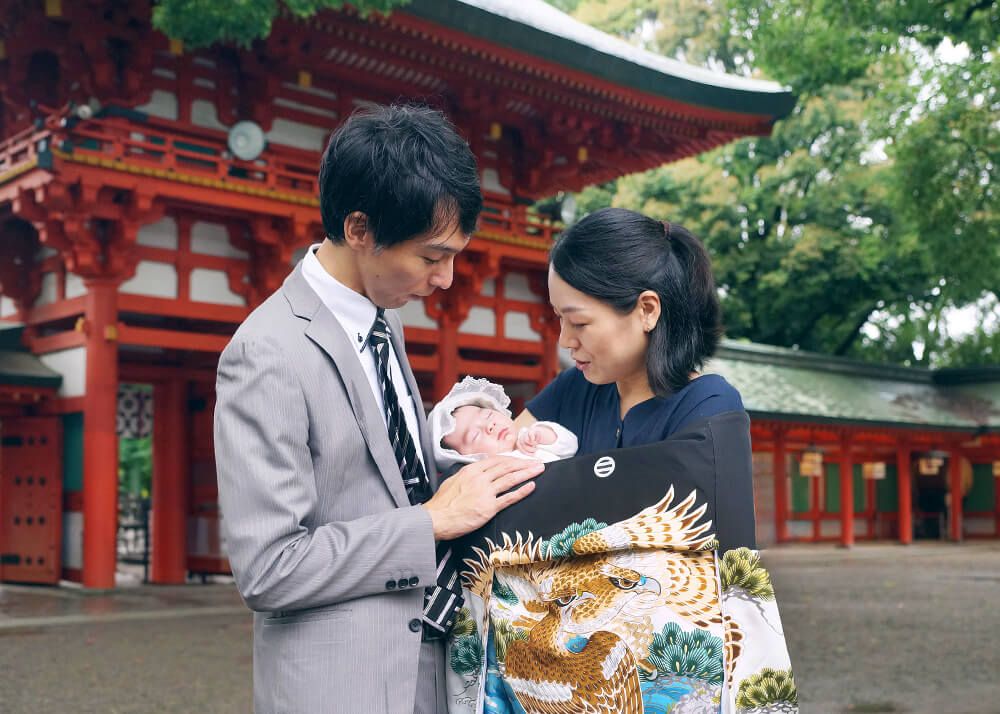 お宮参りの出張撮影で大宮氷川神社の楼門の前で赤ちゃんを抱っこするママ