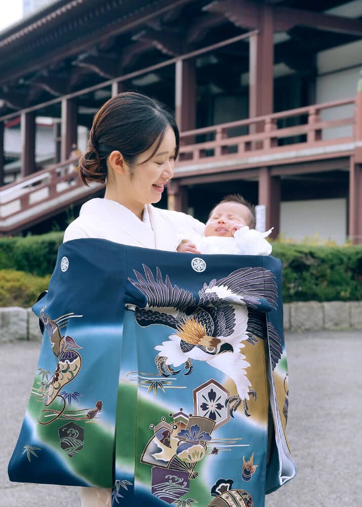お宮参りの出張撮影で増上寺の本堂前で赤ちゃんを抱っこするママ