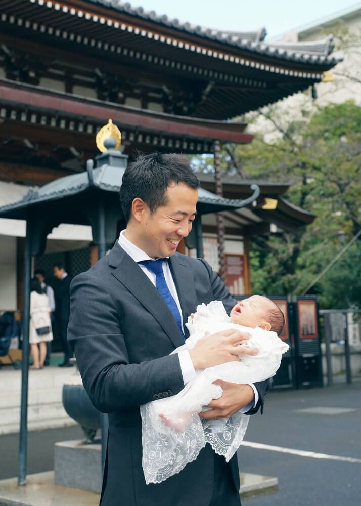 お宮参りの出張撮影で増上寺の本堂前で赤ちゃんを抱っこするパパ