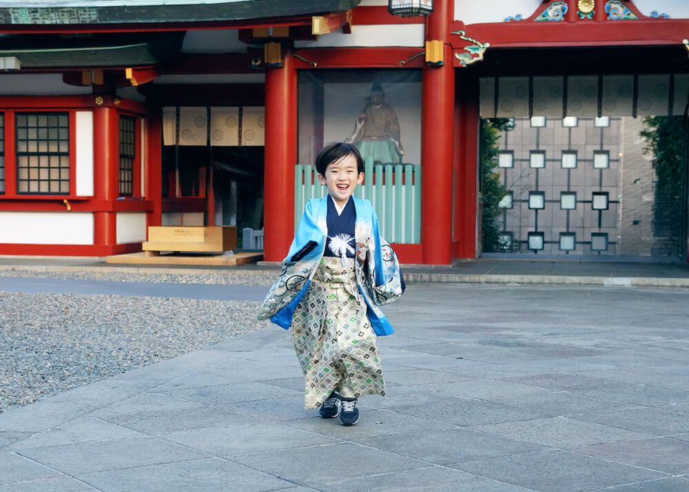 笑顔のお姉ちゃん 赤坂日枝神社での七五三出張撮影で境内でジャンプする男の子の写真