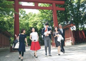 大宮氷川神社の参道を歩くお宮参りの家族の写真