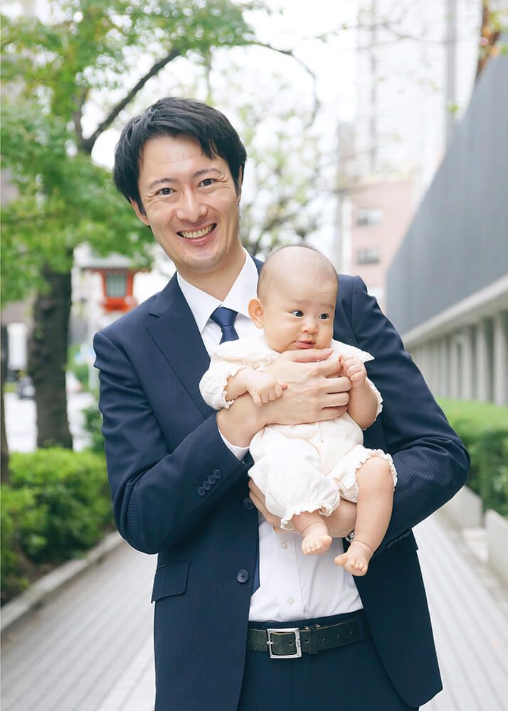 水天宮ロケーションフォト|お宮参り写真紹介 2 お宮参り出張撮影で水天宮のエントランス前で赤ちゃんを抱っこするパパの写真