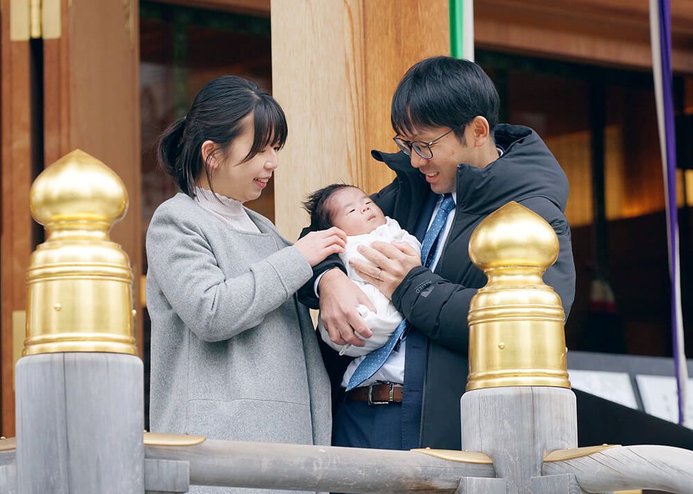 水天宮ロケーションフォト|お宮参り写真紹介 13 お宮参り出張撮影で東京都中央区水天宮の拝殿前で赤ちゃんを抱っこしたパパとママの写真