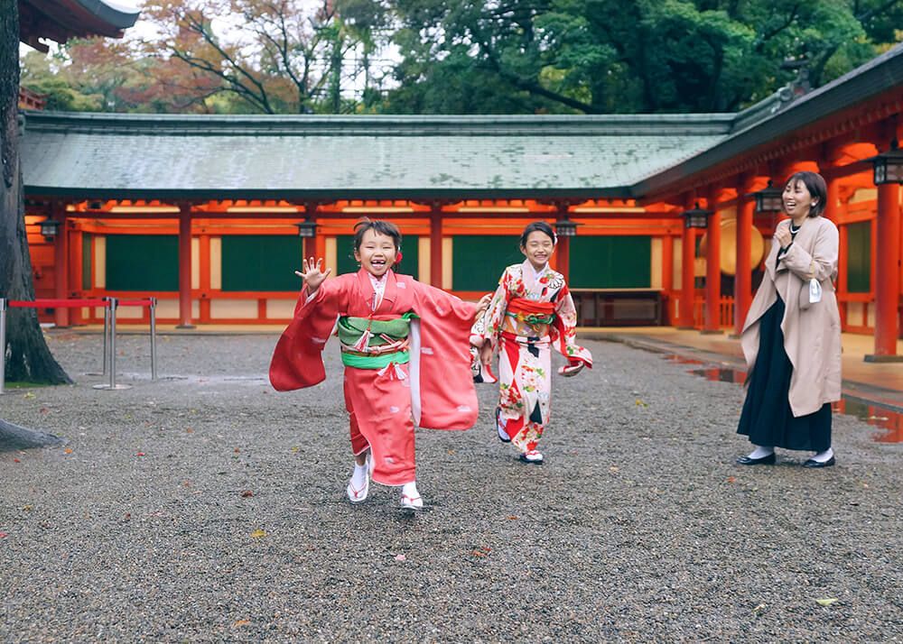 七五三ロケーションフォト-おすすめの時期|大宮氷川神社 14 七五三出張撮影で大宮氷川神社の境内で走る姉妹の写真