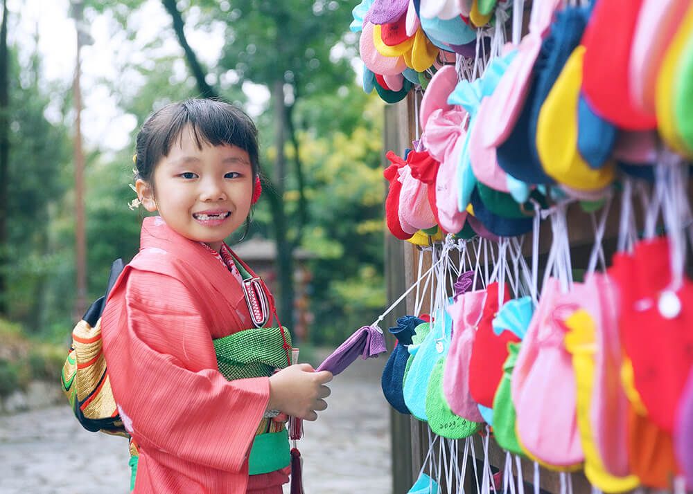 笑顔のお姉ちゃん 七五三出張撮影で大宮氷川神社のふくろ絵馬を手にする妹の写真