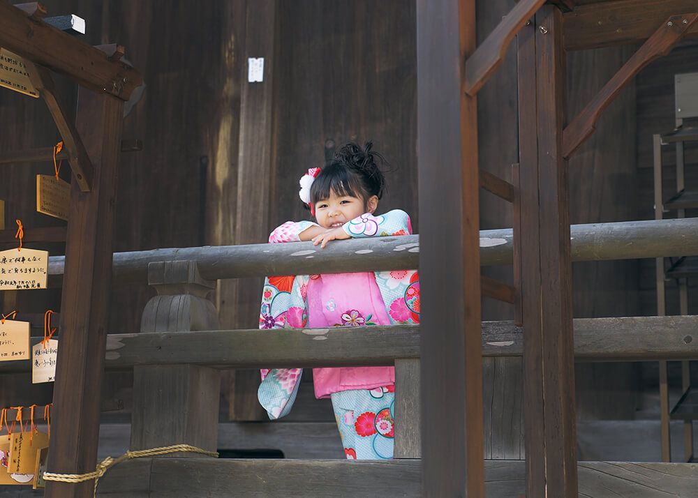 七五三出張撮影で所沢神明社の本殿の手すりに寄りかかって笑顔の女の子の写真