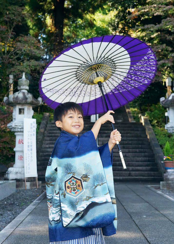 七五三出張撮影で中氷川神社の参道で和傘で遊ぶ男の子の写真