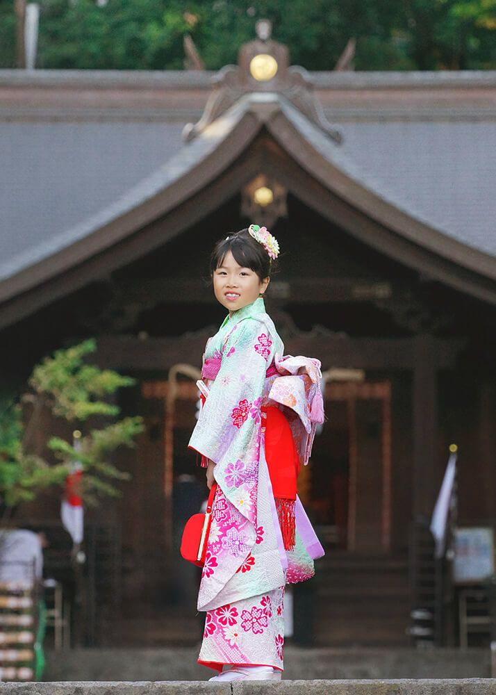 七五三出張撮影で和光市白子熊野神社の本殿前ででポーズをとるで7歳女の子の写真