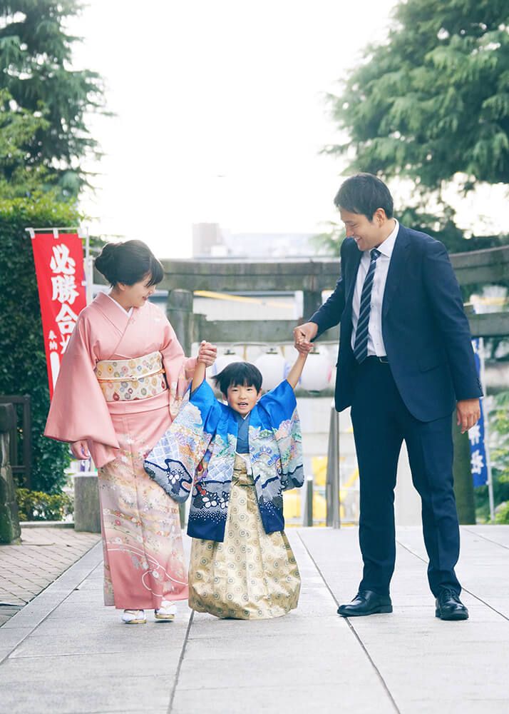 七五三出張撮影で中野沼袋氷川神社の参道を歩く男の子と家族の写真