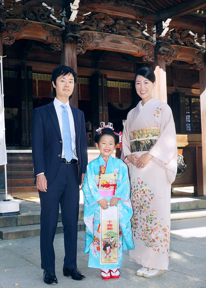七五三出張撮影で牛嶋神社の本殿前で7歳女の子と家族の写真