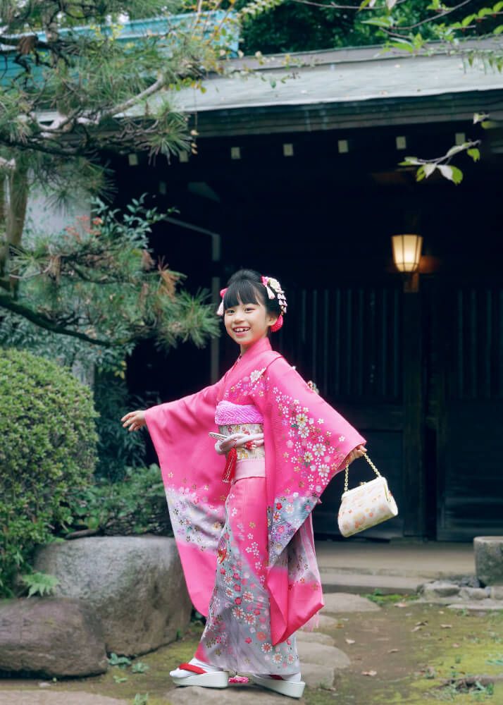 庭園の木漏れ日の中で微笑む7歳女の子の振袖姿｜代々木八幡宮七五三写真