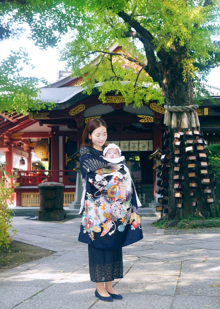 素盞嗚神社|お宮参り・七五三・お食い初め写真 12 お宮参り出張撮影で素盞嗚(スサノオ)神社の参道で赤ちゃんを抱っこするママの写真