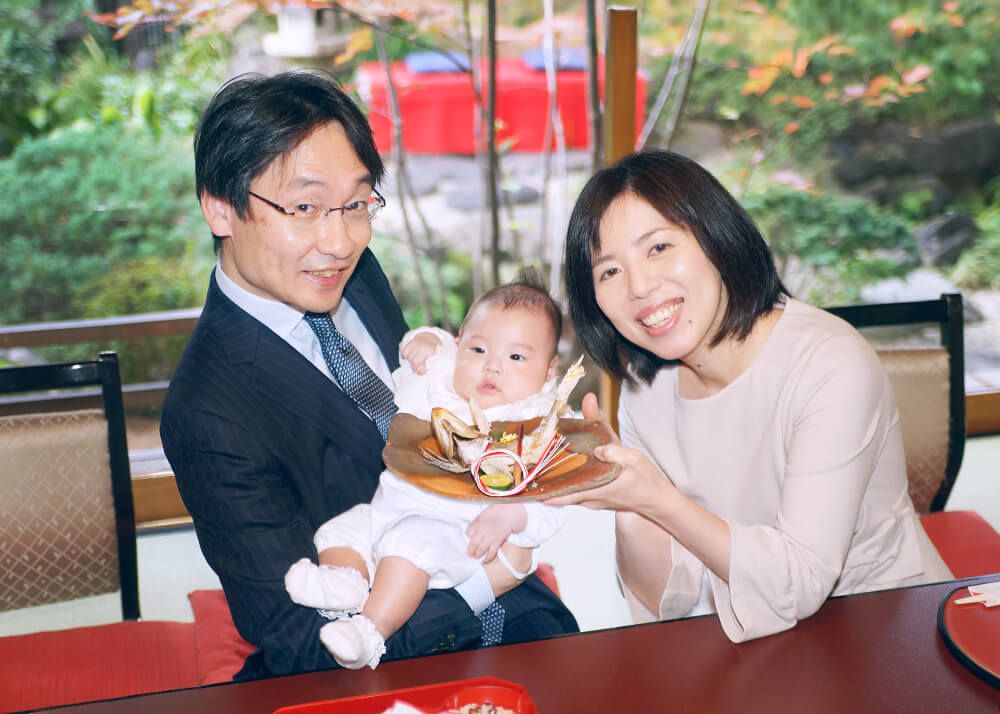 お宮参り・お食い初めロケーションフォト|赤坂日枝神社→芝とうふ屋うかい 22 芝とうふ屋うかいでの出張撮影でお食い初めで鯛を赤ちゃんに見せるママの写真