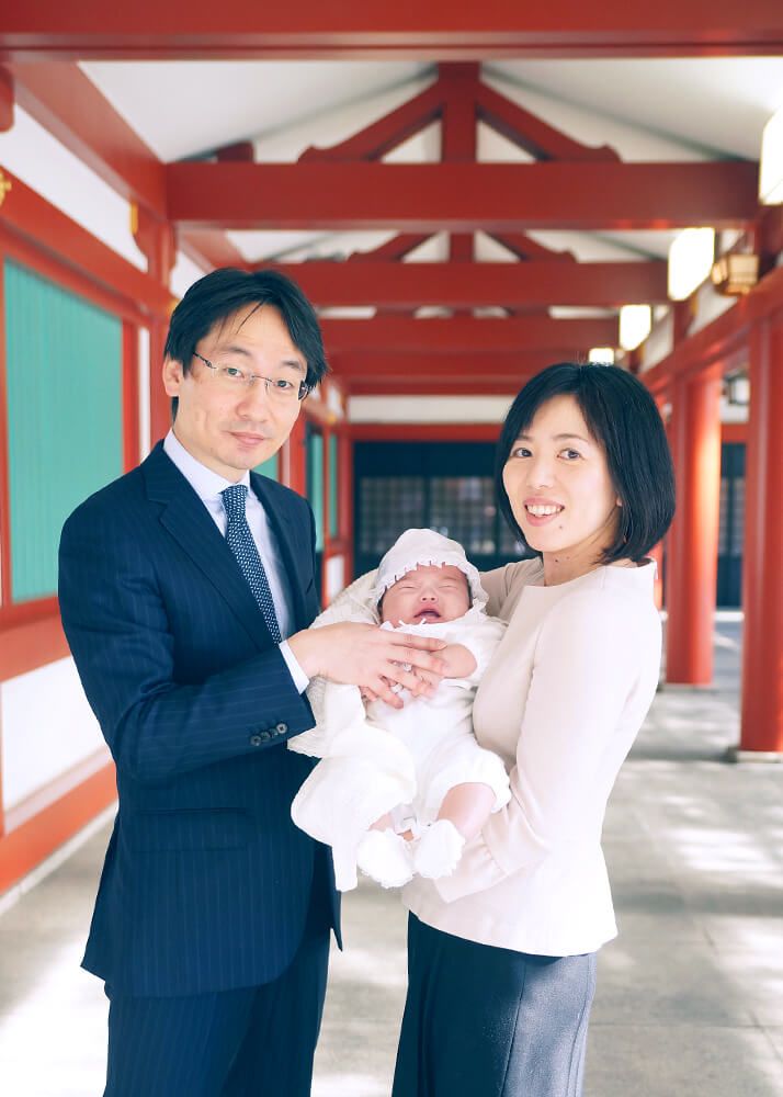 お宮参り・お食い初めロケーションフォト|赤坂日枝神社→芝とうふ屋うかい 10 赤坂日枝神社の回廊でお宮参りの赤ちゃんを抱っこするママとパパの写真