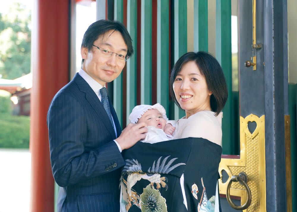 鼻の穴に指が入っているお姉ちゃん お宮参りの祝い着姿でパパとママに抱かれる赤ちゃんの写真|赤坂日枝神社出張撮影