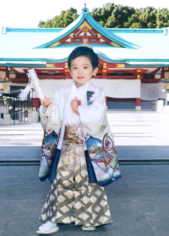 赤坂日枝神社での七五三出張撮影で神門の下で千歳飴を持つ男の子の写真