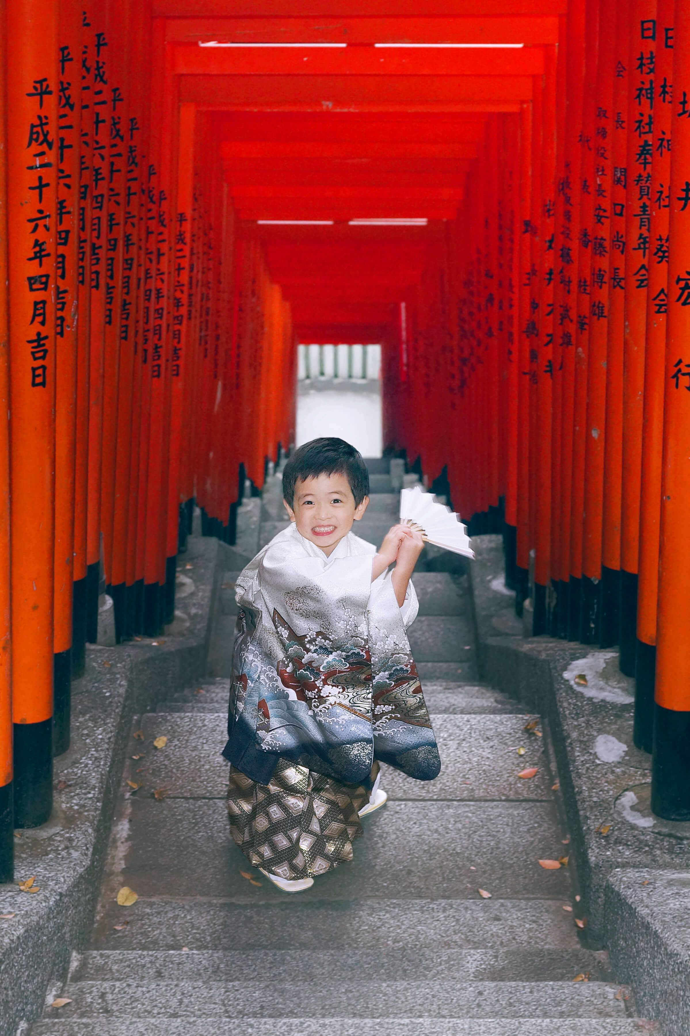 赤坂日枝神社での七五三出張撮影で赤い鳥居の中ではしゃぐ男の子の写真